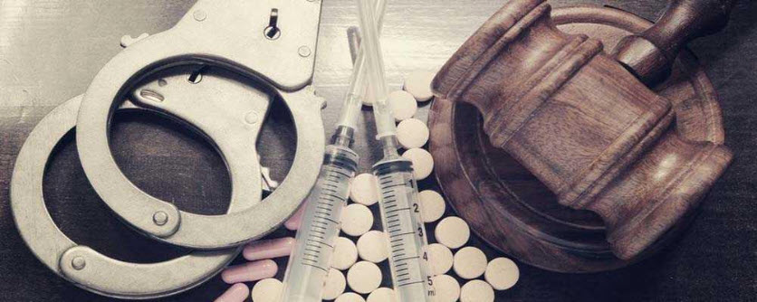 gavel, handcuffs, pills, and syringes