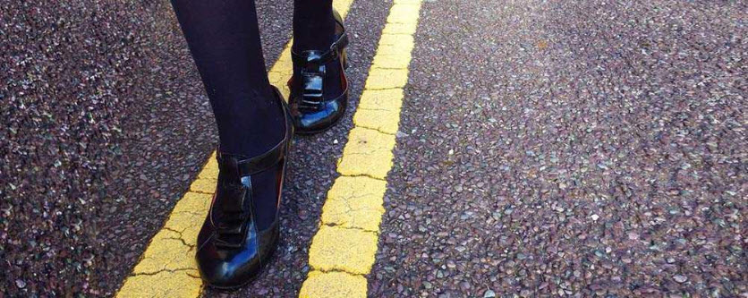 Feet walking between lines on road